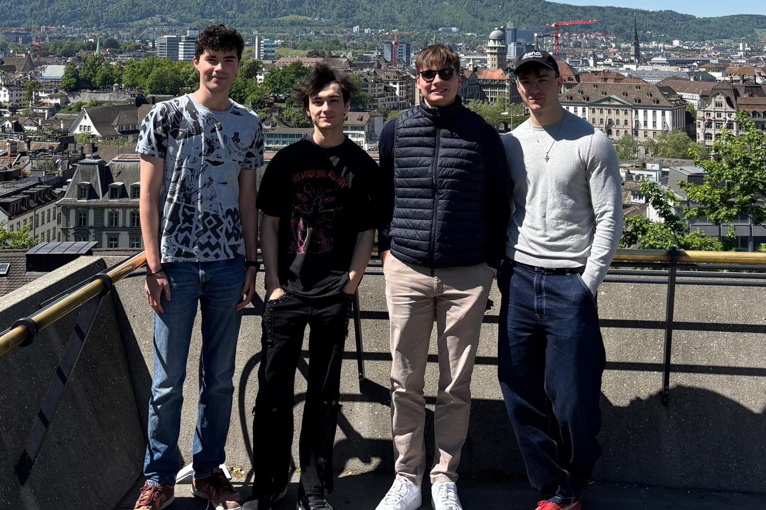 The four-person team standing on a terrace above the Zürich rooftops